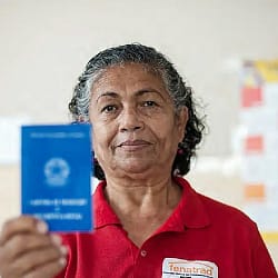 Imagem de Trabalhadora doméstica mostrando carteira de trabalho