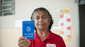 Imagem de Trabalhadora doméstica mostrando carteira de trabalho